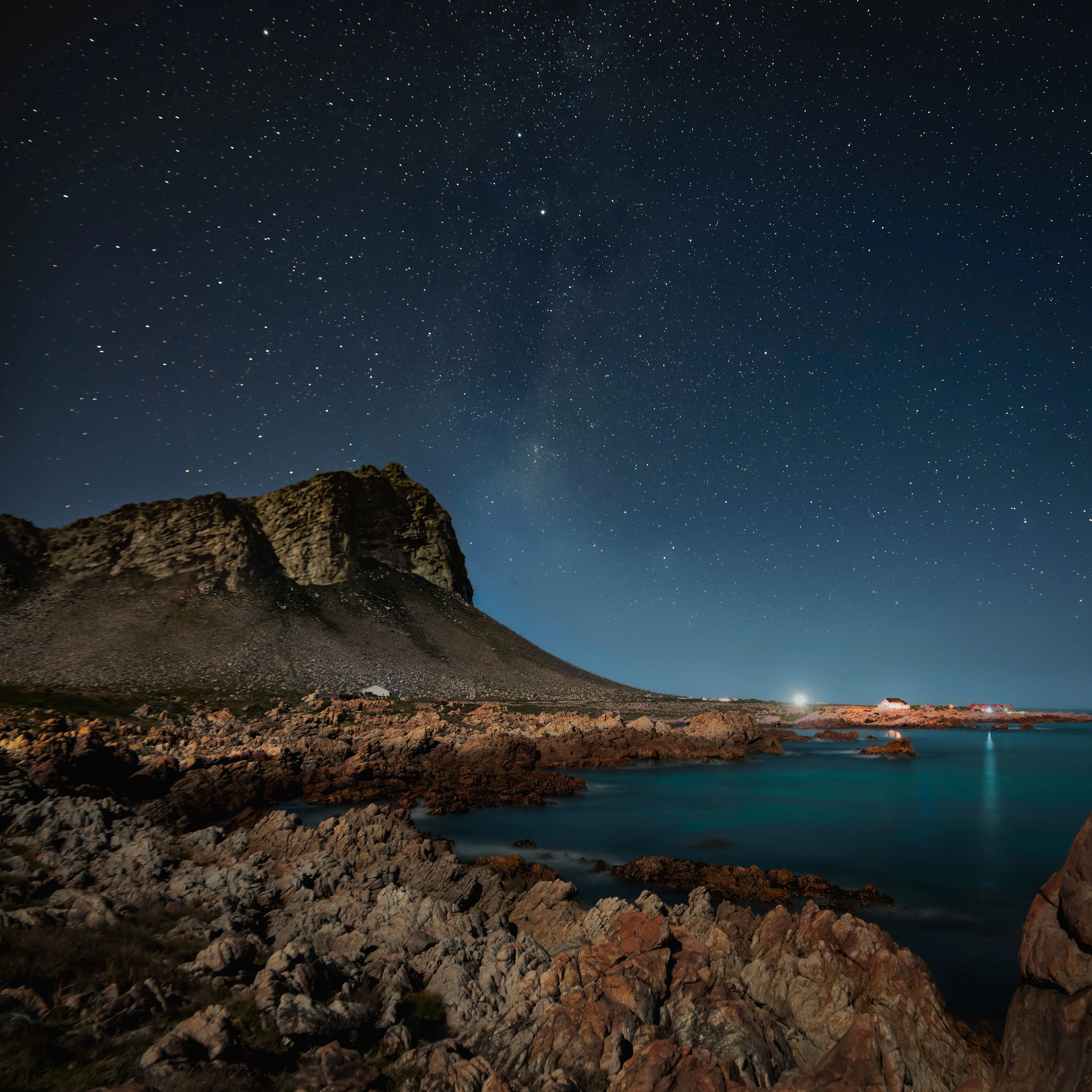 Starry night sky over a mountain silhouette